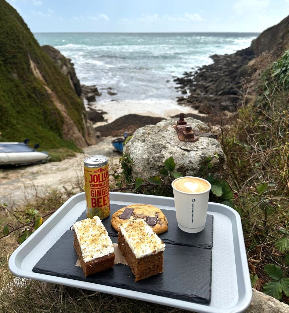 cakes and drink in front of Porthgwarra Cove